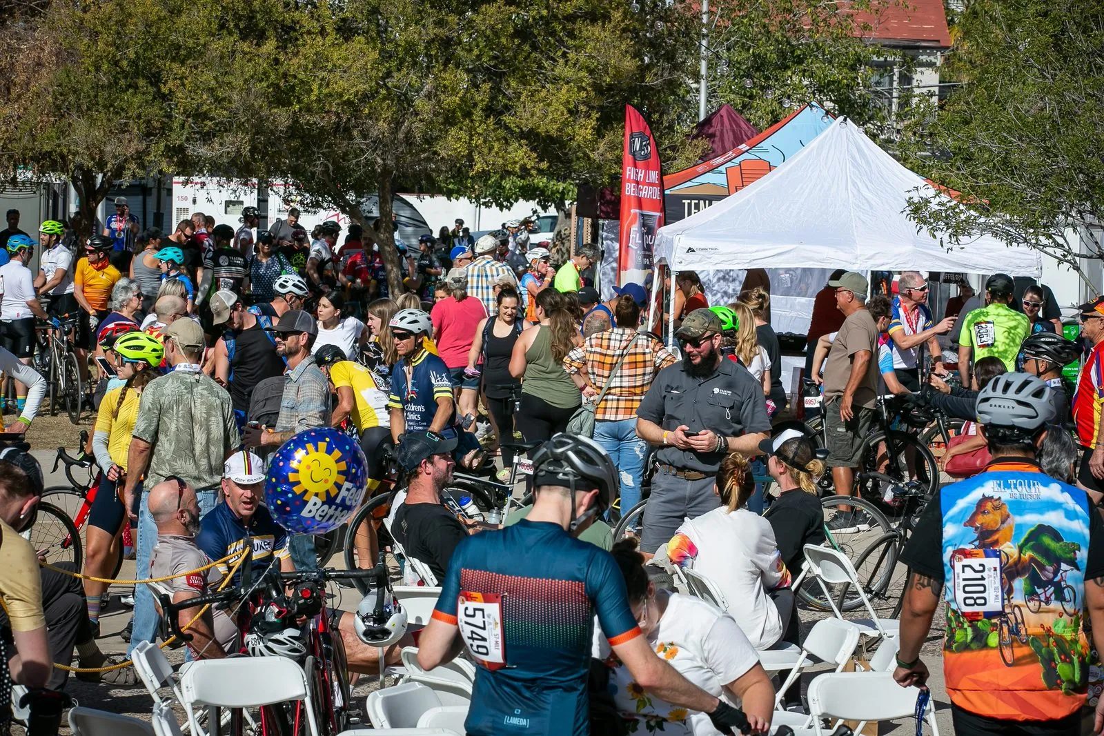A dense crowd moving between vendor tents and parked bikes at an outdoor expo.
