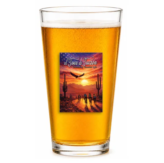 Pint glass of beer with the 43rd El Tour de Tucson sunset artwork, on white